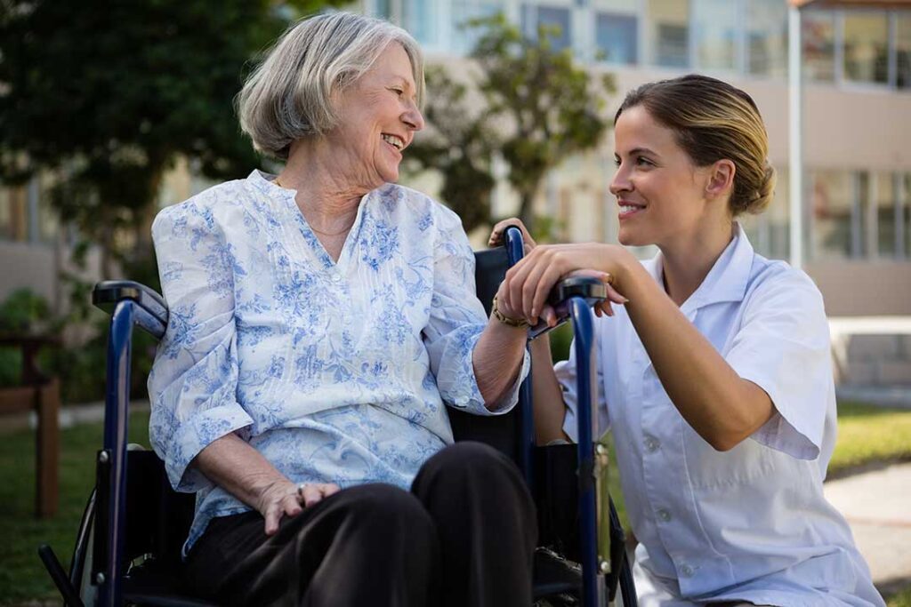 Adult children visiting an older parent in a cozy common room, sharing conversation and laughter.