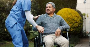 Older resident speaking with an interviewer in a bright assisted living sitting room